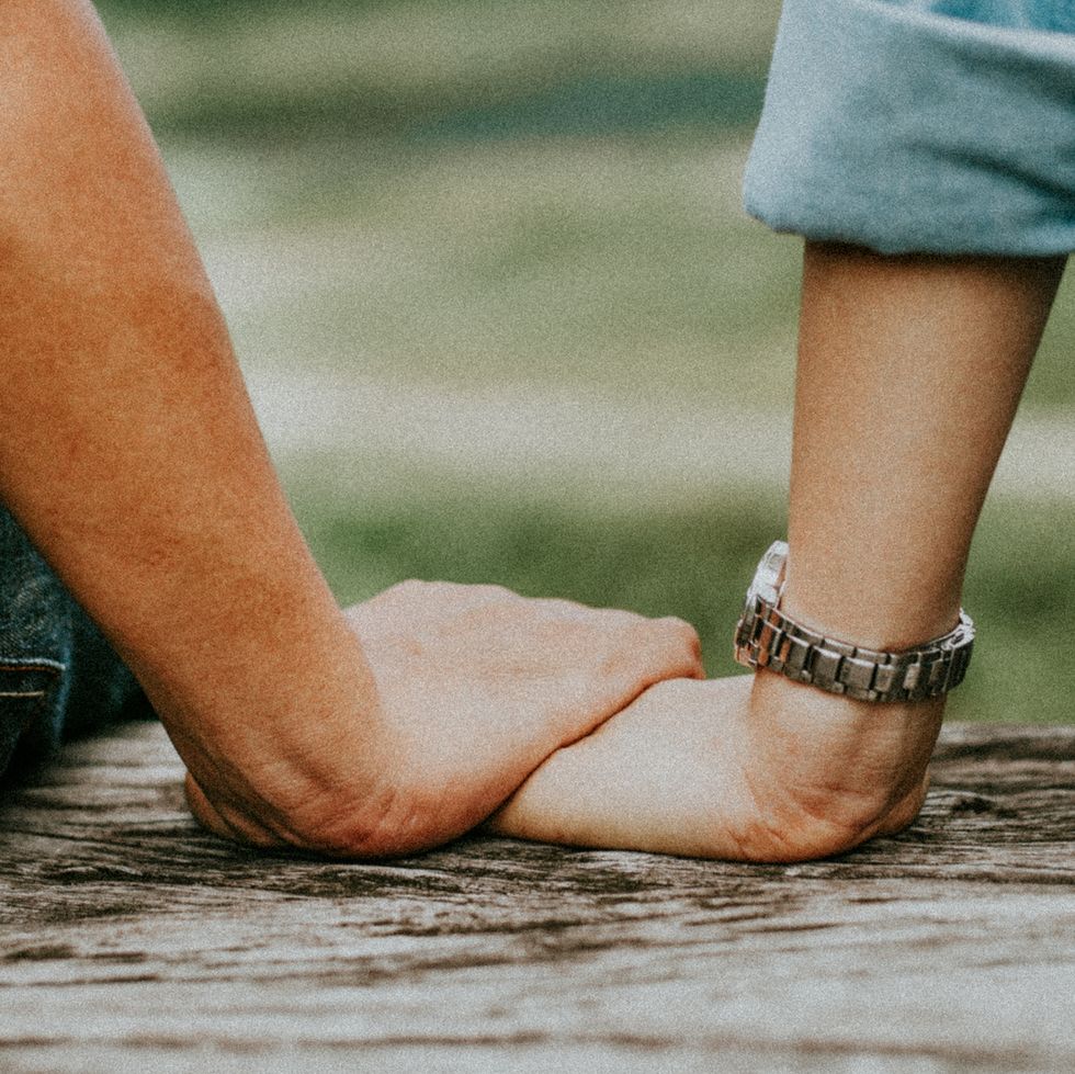 cropped-image-of-couple-holding-hands-while-sitting-royalty-free-image-1576699284.jpg